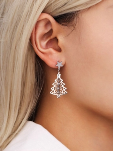 Detailed view of silver Christmas tree earrings with star stud worn by a model