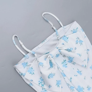 Detail view of white and blue floral dress featuring a large front bow and thin straps