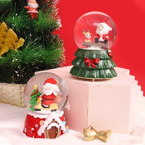Luminous Christmas snow globe music box with Santa Claus and reindeer on festive red background