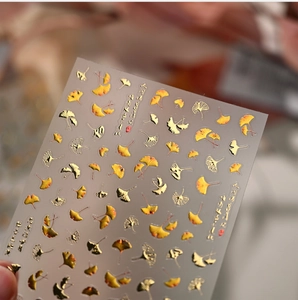 Detailed 3D embossed nail stickers featuring yellow ginkgo leaves and golden foil lines