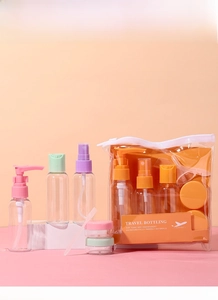 Close-up of travel toiletries set with colorful caps, cream jars and funnel in clear PVC pouch