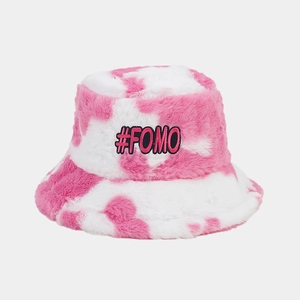 Detail of pink cow print faux fur bucket hat featuring a black #FOMO embroidered patch