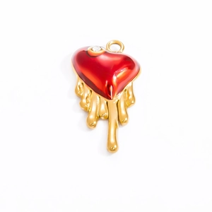 Detail of red enamel heart pendant with gold molten texture and sparkling white rhinestone