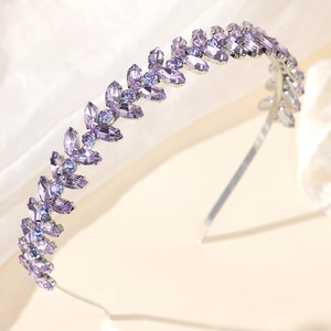 Detailed close-up of a silver headband with purple rhinestones in a leaf vine pattern