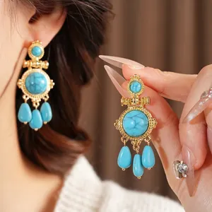 Vintage bohemian gold earrings with blue turquoise stones and teardrop dangle charms