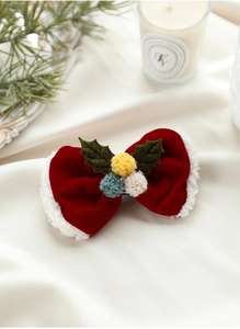 Gros plan d'un nœud papillon de Noël en velours rouge avec bois de renne et pompons
