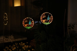 Detail of decorative solar garden stake lights with gnome and squirrel silhouettes
