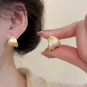 Elegant gold brushed round stud earrings for women with minimalist shell-like design
