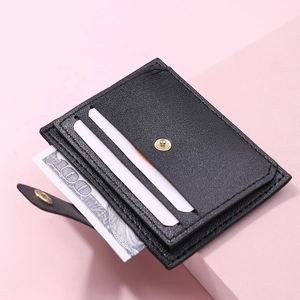 Detail of black lychee leather card holder featuring multiple slots and metal snap closure