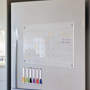 Clear acrylic magnetic dry erase calendar with six colored markers on a fridge surface