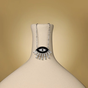 Detailed shot of S925 sterling silver evil eye pendant with baguette zircon on ceramic vase