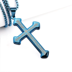 Detailed close-up of blue stainless steel cross pendant with engraved Lord's Prayer text