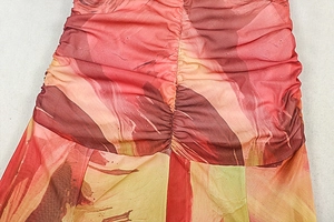 Close-up of vibrant red and orange floral mesh fabric with central ruched detail