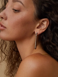 Close-up of wood grain teardrop earring on model showing elegant long drop style