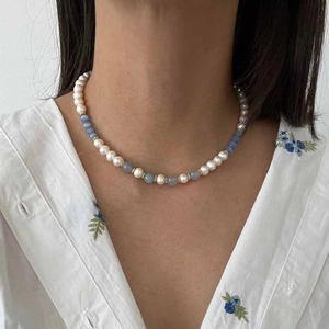 Detail of glacier blue cat eye beads and pearls necklace with heart pendant