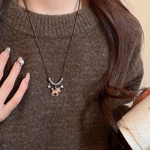 Macro view of a retro wooden rocking horse pendant and silver stars on a long necklace