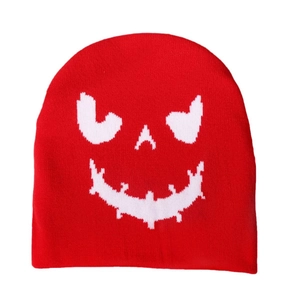 Detail of red knit beanie featuring white Halloween pumpkin jacquard weave pattern