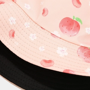 Detailed macro view of pink peach print canvas fabric on a reversible bucket hat