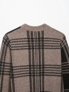 Close-up of knit sweater with dark brown plaid pattern and ribbed crew neck texture