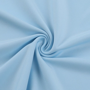 Gros plan sur la texture du tissu bleu clair avec un drapé élégant et des fibres lisses