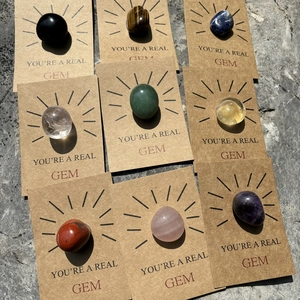 Polished natural crystal gemstones on kraft paper cards with You're a Real Gem text