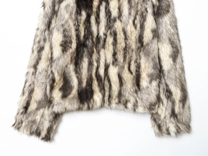 Close-up of faux fur coat texture showing gray, white, and black natural striped fibers