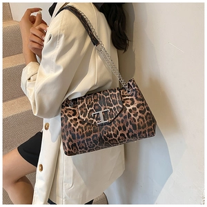 Dettaglio della borsa leopardata con chiusura a T argentata e tracolla a catena chic