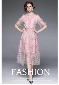Détail d'une robe de fée rose à volants en dentelle avec broderie dorée et tulle
