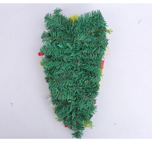 Close-up of green artificial pine branches with red berry accents for Christmas decoration