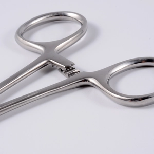 Macro view of stainless steel piercing tool showing the precise ratchet locking mechanism