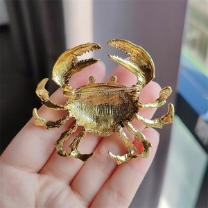 Detail view of the golden crab brooch back side showing sturdy alloy pin and metal texture