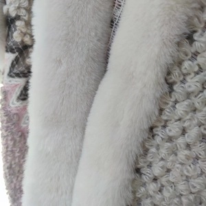 Detailed shot of pink and gray woven fabric paired with soft white faux rabbit fur trim