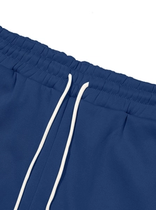 Detail of navy blue cargo pants waist featuring white drawstring and knit texture