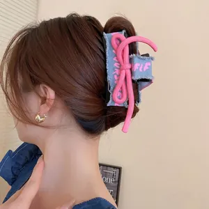 Denim bow hair claw clip with pink rope knot and distressed edges in street style