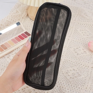 Dettaglio del beauty case in rete di nylon nero con cerniera su fondo in pizzo