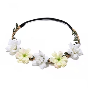 Floral bridal headband with white flowers and green leaves on a braided strap