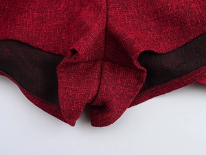 Dettaglio ravvicinato della gonna in tweed rosso con bordo nero e cuciture rifinite