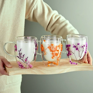 Double walled glass cups with dried flowers and wooden tray for elegant gifts