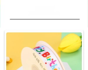 Close-up of white polyester birthday ribbon with colorful Happy Birthday print on a roll