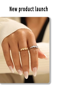 Detail of gold and silver wavy rings with pavé cubic zirconia worn by model
