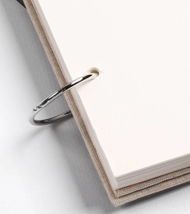 Detailed macro view of the metal binder rings and linen textured cover on 32K sketchbook