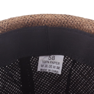 Interior detail of a straw sun hat showing 100% paper material label and sweatband