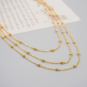 Three-layer minimalist gold titanium steel necklace with spaced bead chains and polished finish
