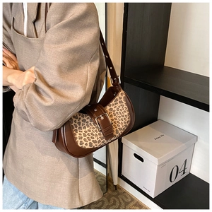 Détail du sac léopard avec bandoulière en cuir marron ajustable porté par un mannequin