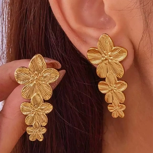 Vintage style triple flower drop earrings in gold plated stainless steel on model