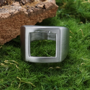 Détail d'une bague en acier brossé argenté avec design géométrique industriel ajouré