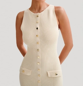 Détails de la maille côtelée et des boutons dorés sur la robe en tricot crème chic