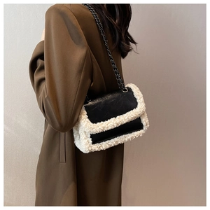 Detail of contrast shearling trim on black leather chain shoulder bag for autumn