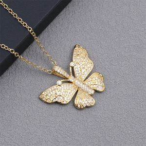 Detail of 18K gold plated copper necklace with a sparkling butterfly pendant micro-set with cubic zirconia