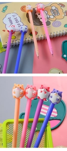 Set of four colorful cartoon hamster pens displayed on a notebook and in a green pen holder